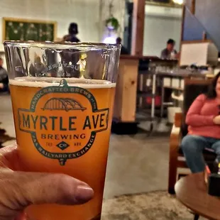 a hand holding a pint of beer