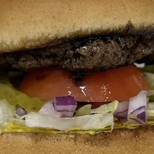 a hamburger with lettuce, tomato, and onion