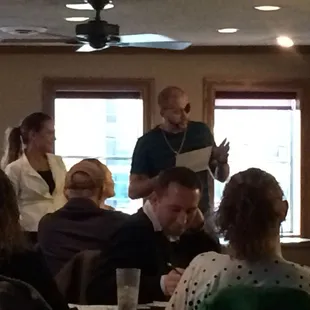 Audience volunteers reading their parts.