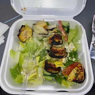 a salad in a styrofoam container