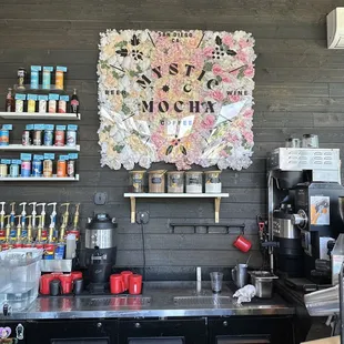 a coffee shop counter with a sign on the wall