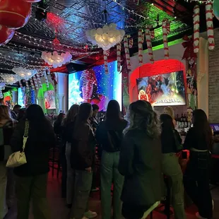a crowd of people standing in a bar