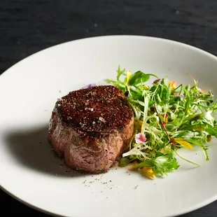 a piece of steak on a white plate
