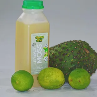 a bottle of liquid and limes