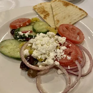 Horiatiki - Tomatoes, cucumbers, red onions, pepperoncini peppers, kalamata olives, feta cheese, white wine vinaigrette, pita bread.