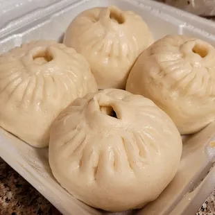 four dumplings in a container