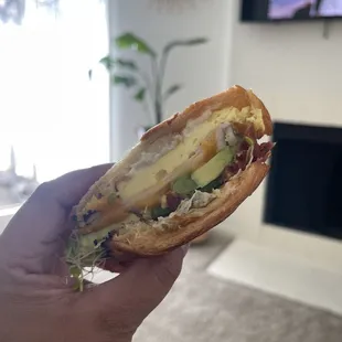 a person holding a sandwich in their hand