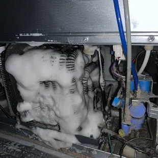 Spraying the condenser clean on refrigerator