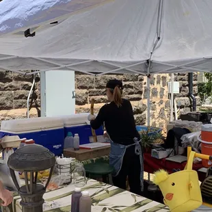 She's cutting the sugar cane stalk in half before putting it into the press