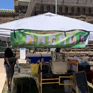 This vendor will use that machine to squeeze or press out sugar cane juice that you can drink straight up or add into their other beverages