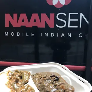 a tray of food in front of a naan seen mobile indian cuisine sign