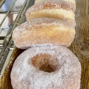 a row of doughnuts on a cooling rack