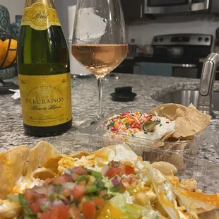 a bottle of wine and a plate of nachos