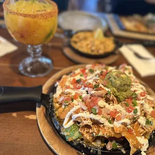 a plate of nachos and a drink