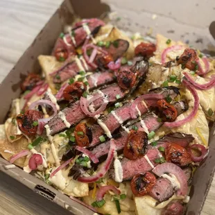 a box of nachos with toppings