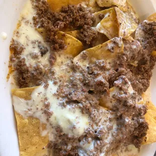 a plate of nachos with ground beef and cheese