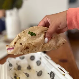 a hand holding a piece of bread