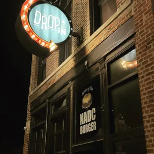 a brick building with a neon sign