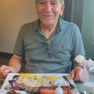 a man sitting at a table with a plate of food