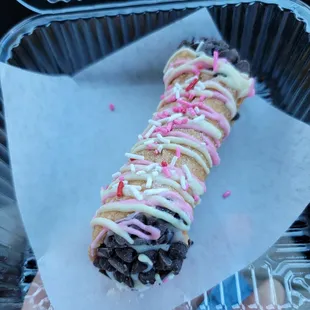 a hand holding a doughnut with sprinkles