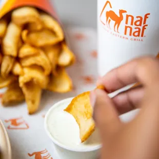 a person dipping a snack into a bowl