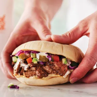 a hand holding a sandwich