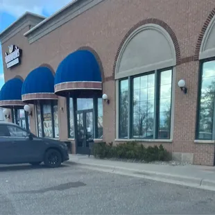 The exterior entrance is the door on the right side with the hours posted on it. There are no other signs with the restaurant name.