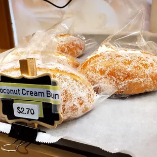 two coconut cream buns on a counter