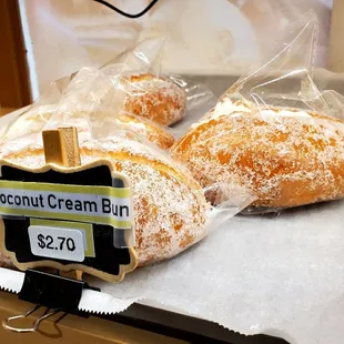 two coconut cream buns on a counter