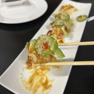 a close up of a sushi with chopsticks
