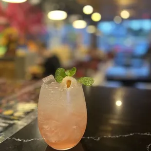a pink drink with a mint garnish