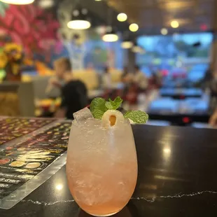 a pink drink with a mint garnish