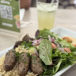 Lamb kofta combination plate with white rice, house salad, hummus, and pita on the side. Yummy mint lemonade in the background.