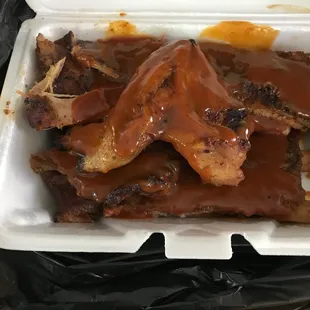 ribs and sauce in a styrofoam container