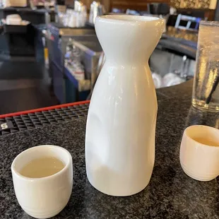 a pitcher and two cups on a counter