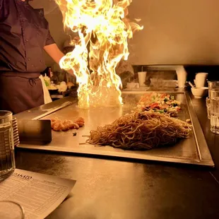 a chef preparing food on a grill
