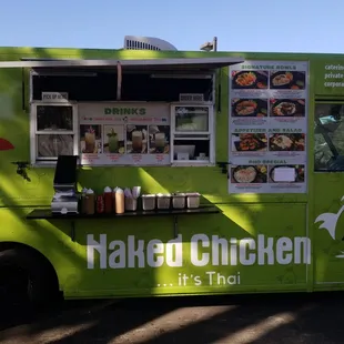 a green food truck parked in a parking lot