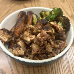 Bowl with brown rice, broccoli, sweet potatoes, and chicken thighs