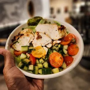 A seasonal bowl with grilled chicken, bibb lettuce, and tomato/cucumber mix.
