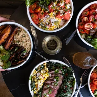 four bowls of food and a glass of wine