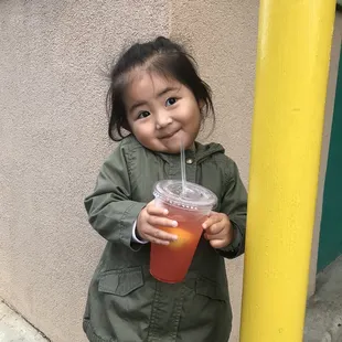  a little girl holding a drink