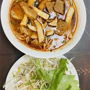 a bowl of soup and a plate of noodles