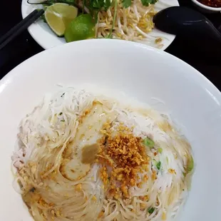 a plate of noodles and a bowl of salad