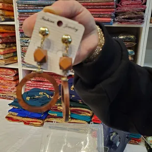 a person holding a pair of earrings