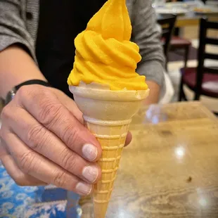 a person holding a cone of ice cream