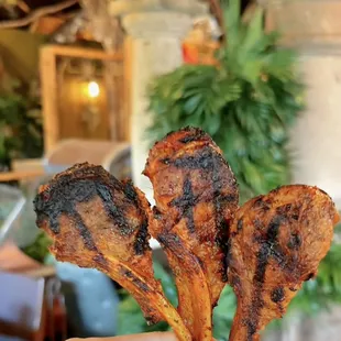 a hand holding a piece of fried chicken