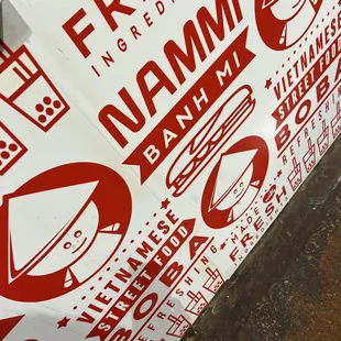 a red and white sign on a sidewalk