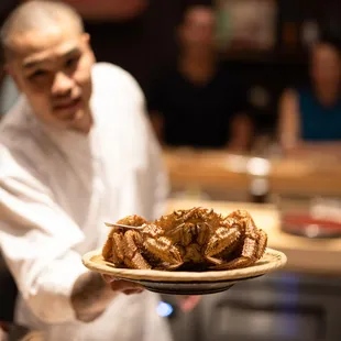 a chef holding a plate of food