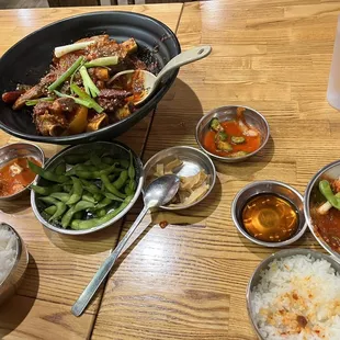 a wooden table with bowls of food and utensils