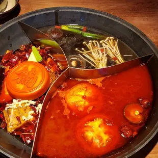 Three broth hotpot. Signature spict on left, mushroom top and tomato bottom